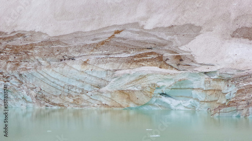 Glacier lake with turquise water against a wall of ice and sand at Mount Edith Cavell