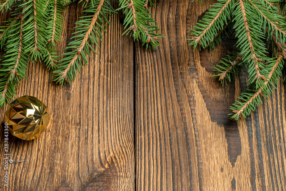 Fir, spruce branches, cones and Christmas tree toys on brown wooden background Fir, spruce branches, cones and Christmas tree toys on brown wooden background