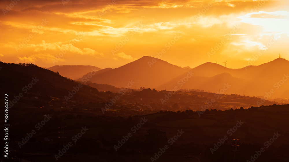 Orange sunset in the mountains with clouds