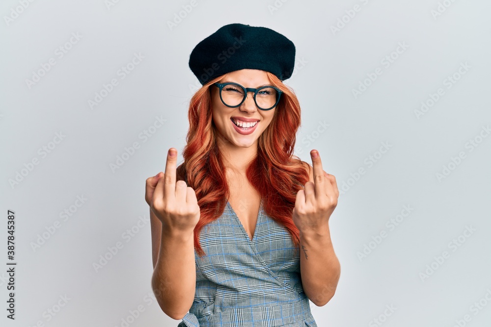 Young redhead woman wearing fashion french look with beret showing middle finger doing fuck you bad expression, provocation and rude attitude. screaming excited Young redhead woman wearing fashion french look with beret showing middle finger doing fuck you bad expression, provocation and rude attitude. screaming excited
