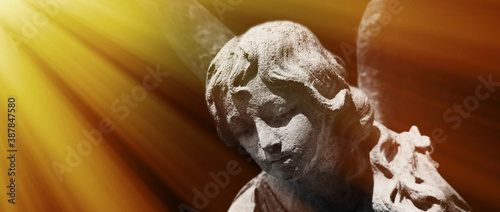 Fototapeta Naklejka Na Ścianę i Meble -  God’s angel of peace in the sunlight. Antique stone statue.