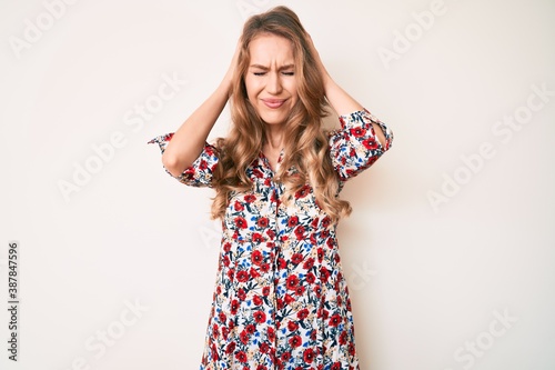 Obraz na plátně Young caucasian woman with blond hair wearing summer dress suffering from headache desperate and stressed because pain and migraine