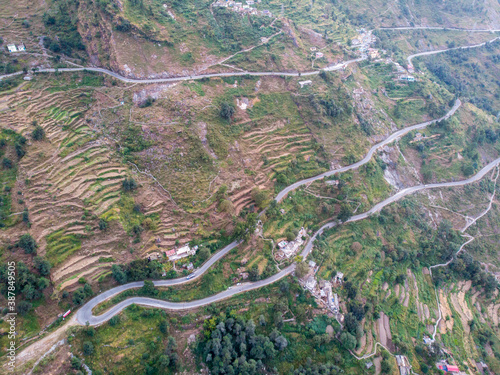 Aerial view of a road through the the mountains. Bird eye view taken through a drone