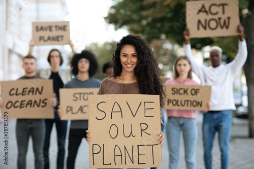 Cheerful lady with SAVE OUR PLANET placard photo
