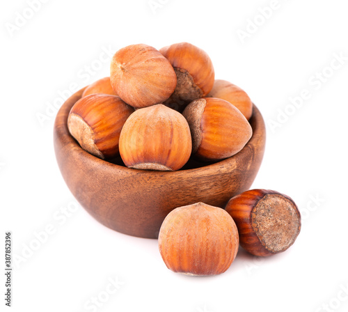 Hazelnut in wooden bowl, isolated on white background. Nut macro. With clipping path.