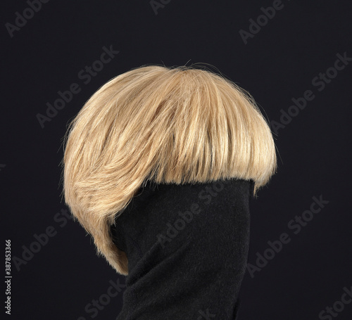 Blonde hair wig with bob cut, side view, black background