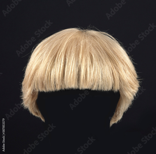 Wig with short blonde hair, front view, black background