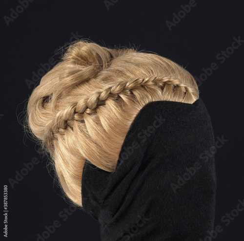 Wig with hairstyle with a braid of blond hair, front view, black background