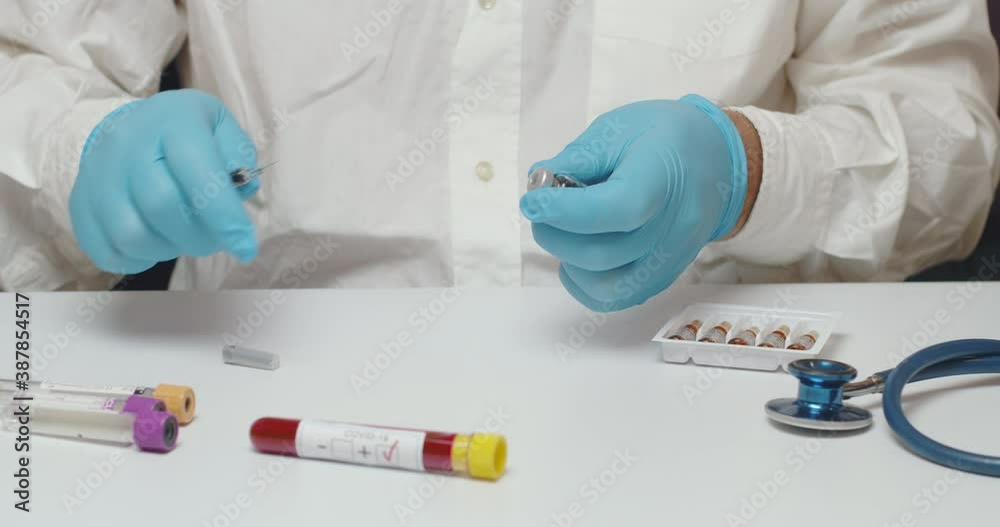 Close up of doctor hands using a syringe during the coronavirus vaccine laboratory test Close up of doctor hands using a syringe during the coronavirus vaccine laboratory test