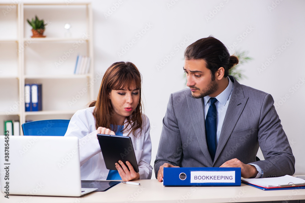 Young female doctor and sick businessman in the office