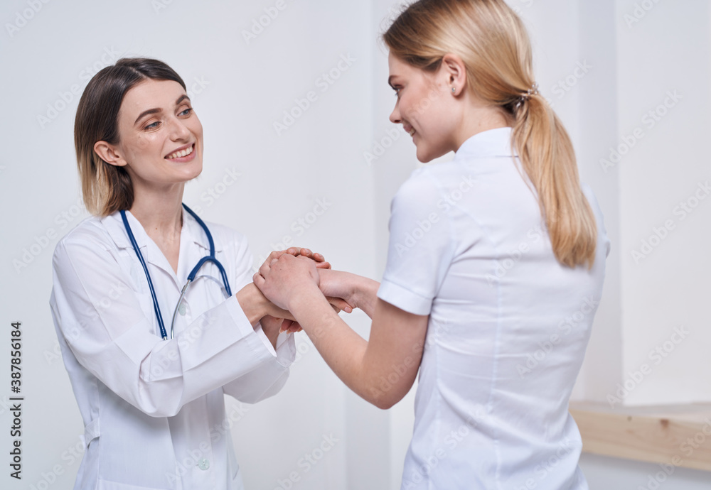 professional doctor nurse shakes hands with a patient and a stethoscope around her neck professional doctor nurse shakes hands with a patient and a stethoscope around her neck