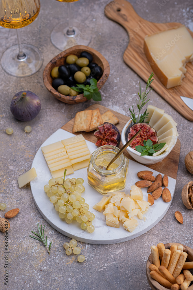 Marble Cheese board with delicous cheeses, nuts, honey and grapes