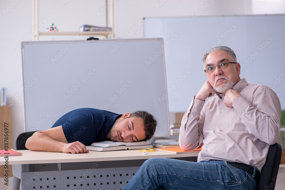 Old teacher and young male student in the classroom Old teacher and young male student in the classroom