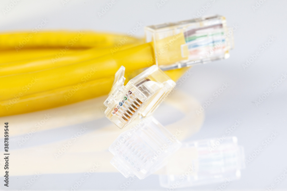 Network ethernet cable with RJ45 connectors isolated on white background. UTP Cable or LAN Cable. yellow color on white background. Close up