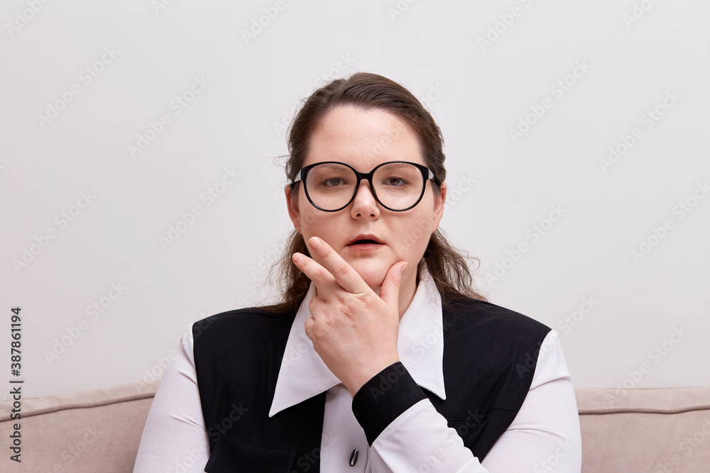 A young business woman plus-size model looks at the camera and says. Black - rimmed eyeglasses. A young business woman plus-size model looks at the camera and says. Black - rimmed eyeglasses.