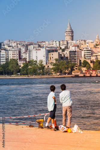 Boys by the sea in istanbul with view of the city seand  Galata Tower photo