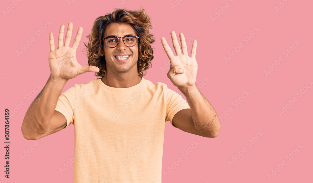 Young hispanic man wearing casual clothes and glasses showing and pointing up with fingers number nine while smiling confident and happy. Young hispanic man wearing casual clothes and glasses showing and pointing up with fingers number nine while smiling confident and happy.