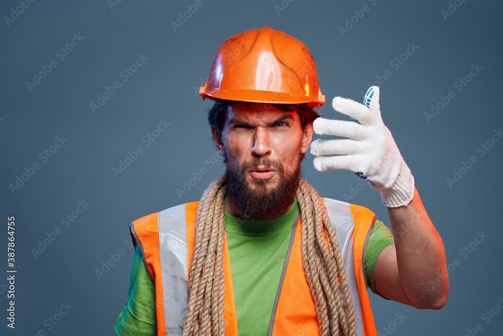 Man in orange paint glove professional construction blue background Man in orange paint glove professional construction blue background