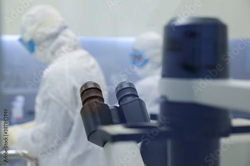 Lab scientists wear protective clothing doing medical research in a science laboratory.