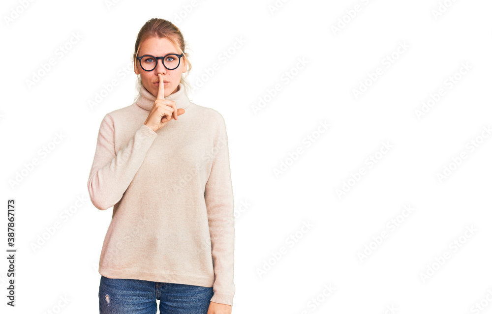 Young beautiful blonde woman wearing turtleneck sweater and glasses asking to be quiet with finger on lips. silence and secret concept. Young beautiful blonde woman wearing turtleneck sweater and glasses asking to be quiet with finger on lips. silence and secret concept.