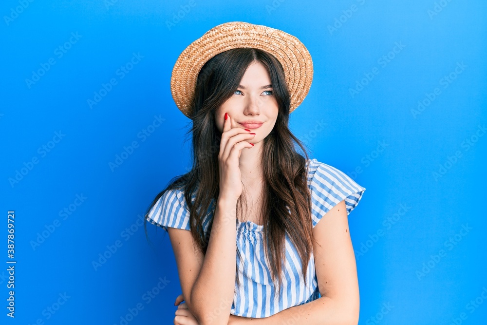 Young beautiful caucasian girl wearing summer hat thinking concentrated about doubt with finger on chin and looking up wondering