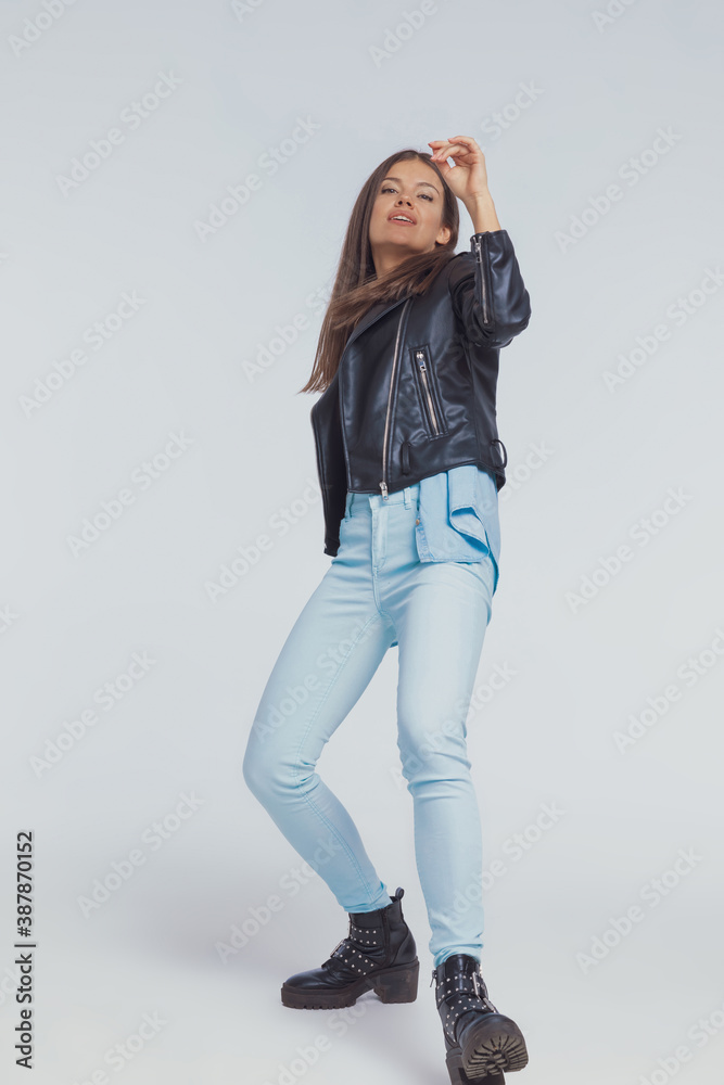 Cheerful fashion model wearing leather jacket while dancing Cheerful fashion model wearing leather jacket while dancing