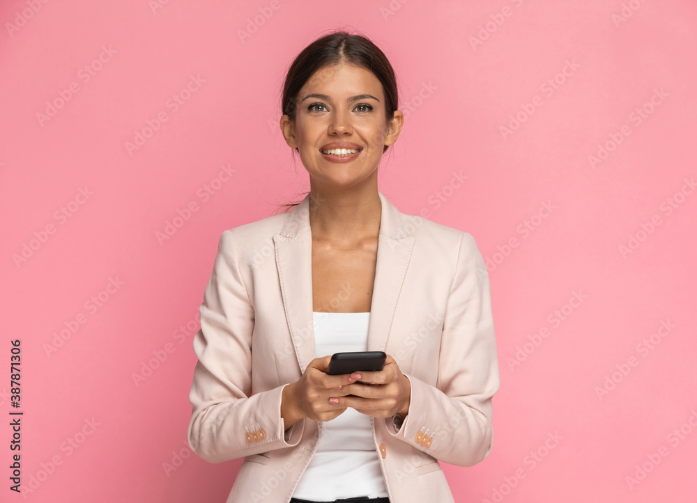 beautiful businesswoman texting on her phone and smiling beautiful businesswoman texting on her phone and smiling