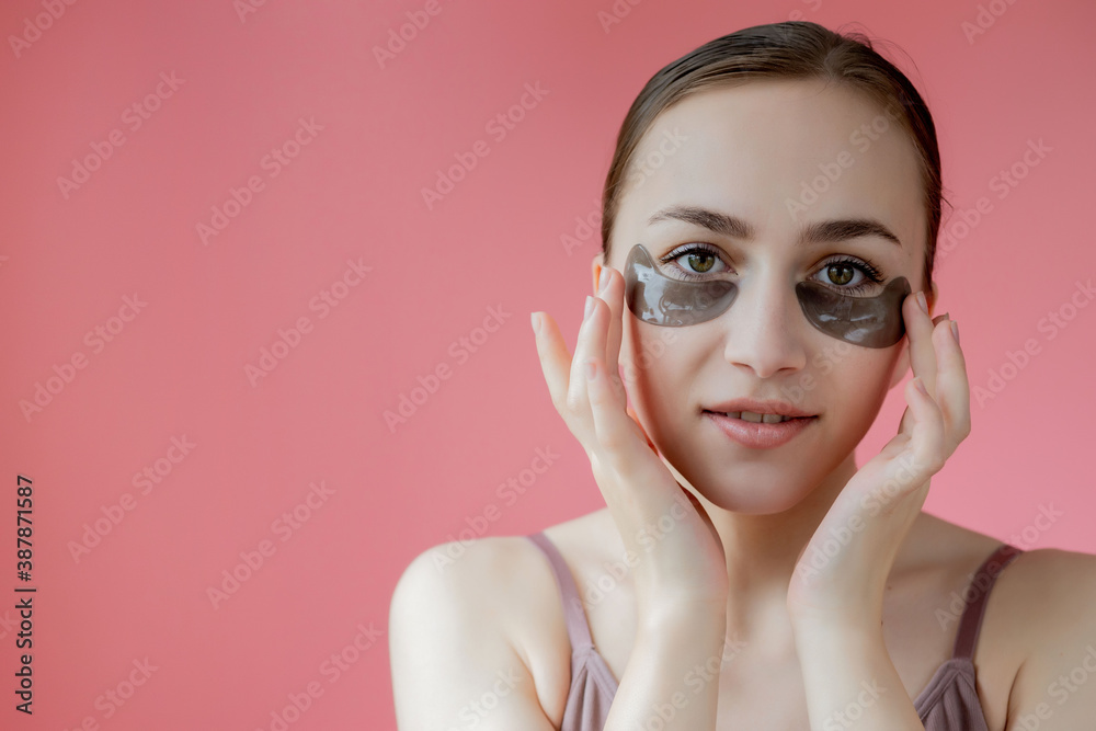 Head shot portrait close up smiling young woman with under eye moisturizing patches mask looking at camera enjoying skincare procedure Head shot portrait close up smiling young woman with under eye moisturizing patches mask looking at camera enjoying skincare procedure