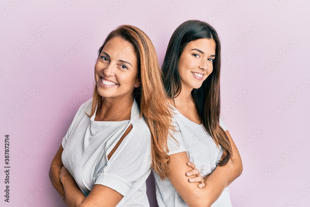 Beautiful hispanic mother and daughter smiling happy over isolated pink background. Beautiful hispanic mother and daughter smiling happy over isolated pink background.
