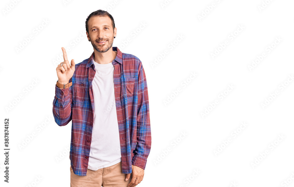 Young handsome man wearing casual clothes pointing finger up with successful idea. exited and happy. number one. Young handsome man wearing casual clothes pointing finger up with successful idea. exited and happy. number one.