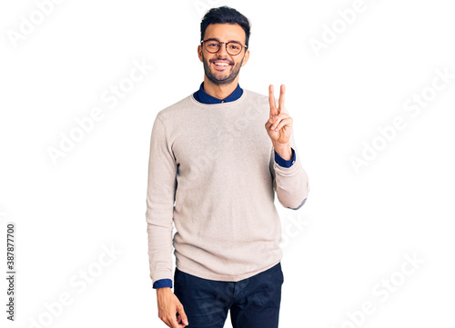 Young handsome hispanic man wearing elegant clothes and glasses showing and pointing up with fingers number two while smiling confident and happy.