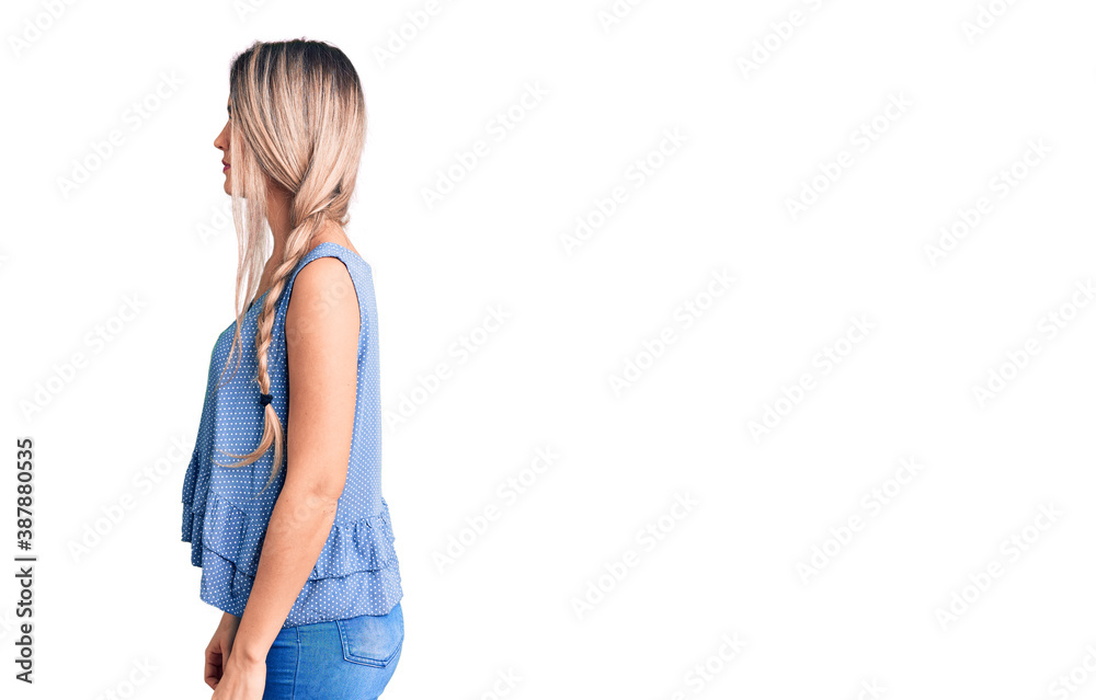 Young beautiful blonde woman wearing casual sleeveless t-shirt looking to side, relax profile pose with natural face with confident smile. Young beautiful blonde woman wearing casual sleeveless t-shirt looking to side, relax profile pose with natural face with confident smile.