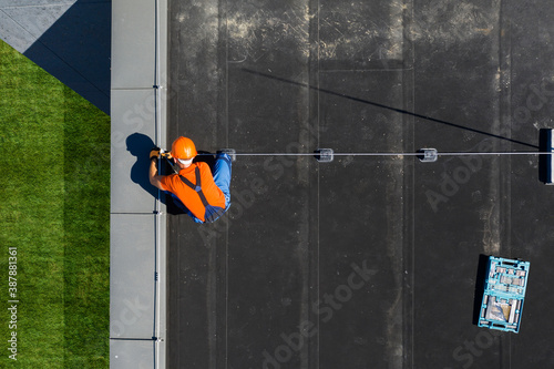 Schilderij op canvas Technician Installing Lightning Protection Rod on Top of Building