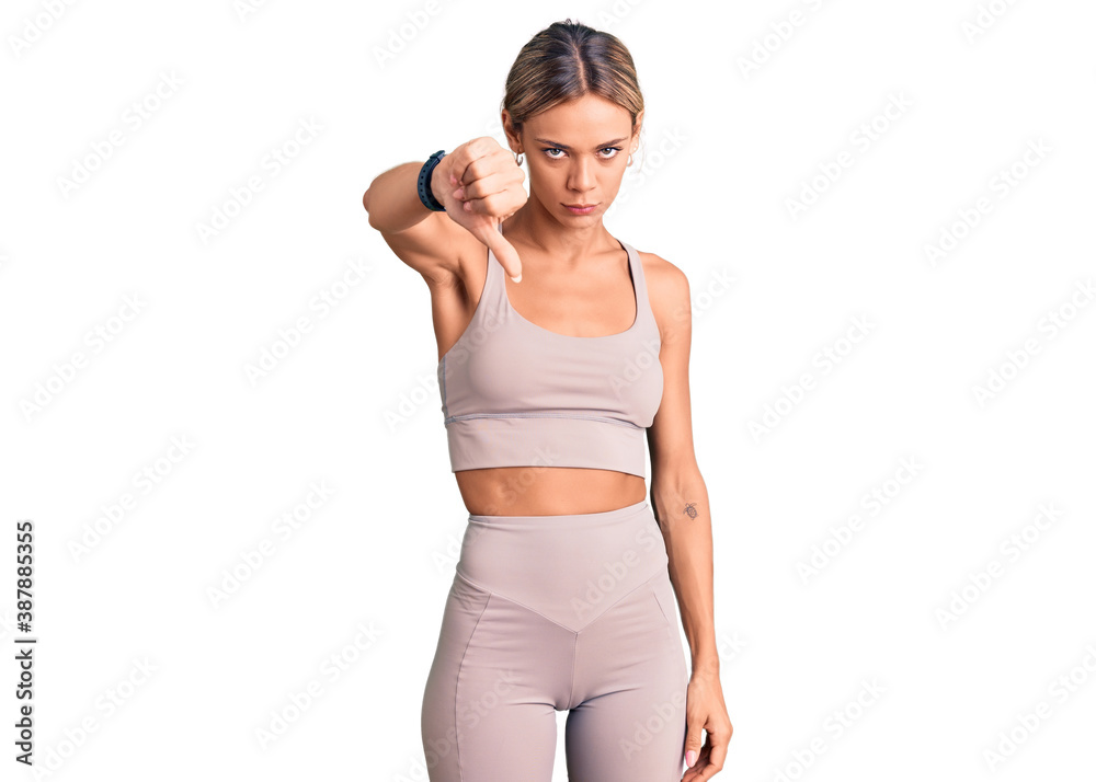 Beautiful caucasian woman wearing sportswear looking unhappy and angry showing rejection and negative with thumbs down gesture. bad expression. Beautiful caucasian woman wearing sportswear looking unhappy and angry showing rejection and negative with thumbs down gesture. bad expression.