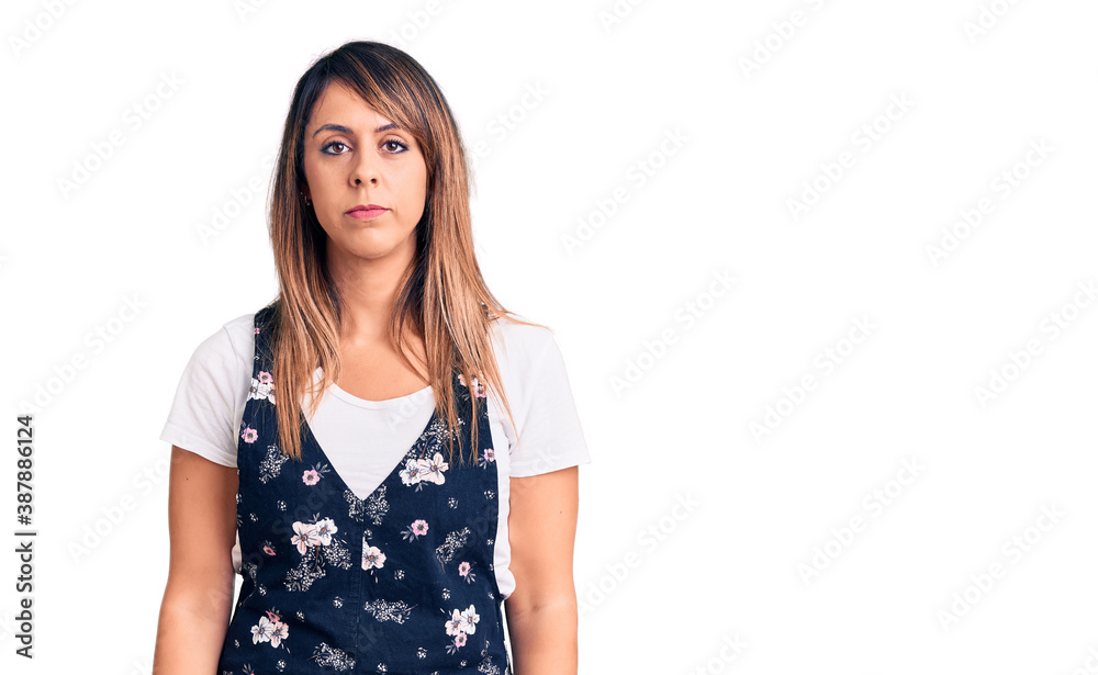 Young beautiful woman wearing casual floral dress with serious expression on face. simple and natural looking at the camera. Young beautiful woman wearing casual floral dress with serious expression on face. simple and natural looking at the camera.