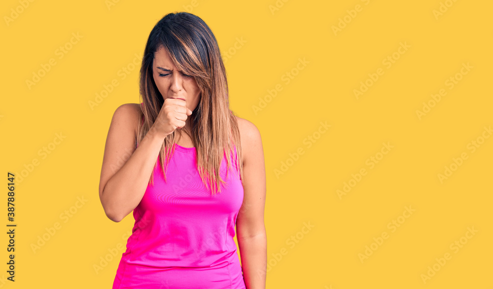 Young beautiful woman wearing sportswear feeling unwell and coughing as symptom for cold or bronchitis. health care concept. Young beautiful woman wearing sportswear feeling unwell and coughing as symptom for cold or bronchitis. health care concept.