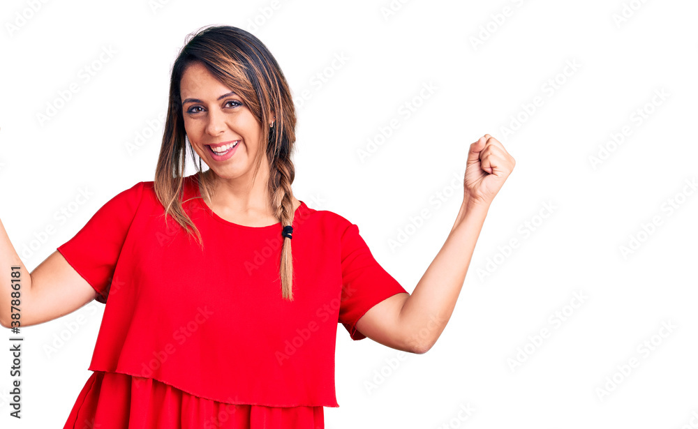 Young beautiful woman wearing casual t-shirt screaming proud, celebrating victory and success very excited with raised arms Young beautiful woman wearing casual t-shirt screaming proud, celebrating victory and success very excited with raised arms