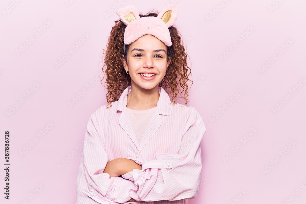 Beautiful kid girl with curly hair wearing sleep mask and pajamas happy face smiling with crossed arms looking at the camera. positive person. Beautiful kid girl with curly hair wearing sleep mask and pajamas happy face smiling with crossed arms looking at the camera. positive person.