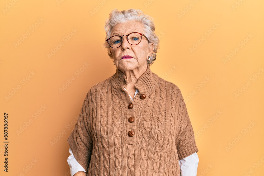 Senior grey-haired woman wearing casual clothes and glasses relaxed with serious expression on face. simple and natural looking at the camera. Senior grey-haired woman wearing casual clothes and glasses relaxed with serious expression on face. simple and natural looking at the camera.