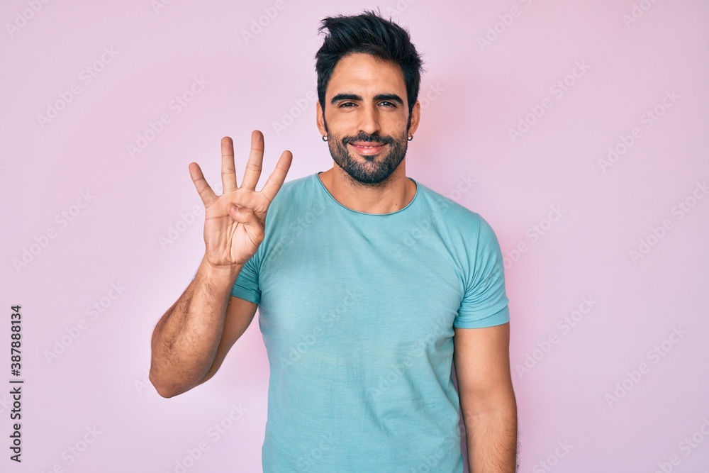 Handsome hispanic man with beard wearing casual clothes showing and pointing up with fingers number four while smiling confident and happy. Handsome hispanic man with beard wearing casual clothes showing and pointing up with fingers number four while smiling confident and happy.
