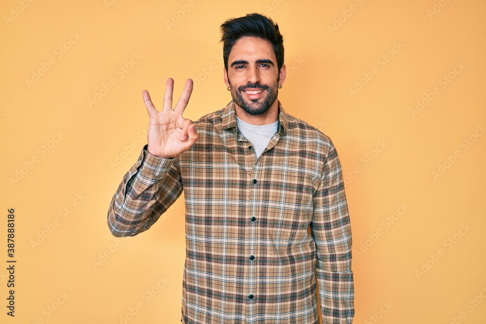 Handsome hispanic man with beard wearing casual clothes showing and pointing up with fingers number three while smiling confident and happy. Handsome hispanic man with beard wearing casual clothes showing and pointing up with fingers number three while smiling confident and happy.