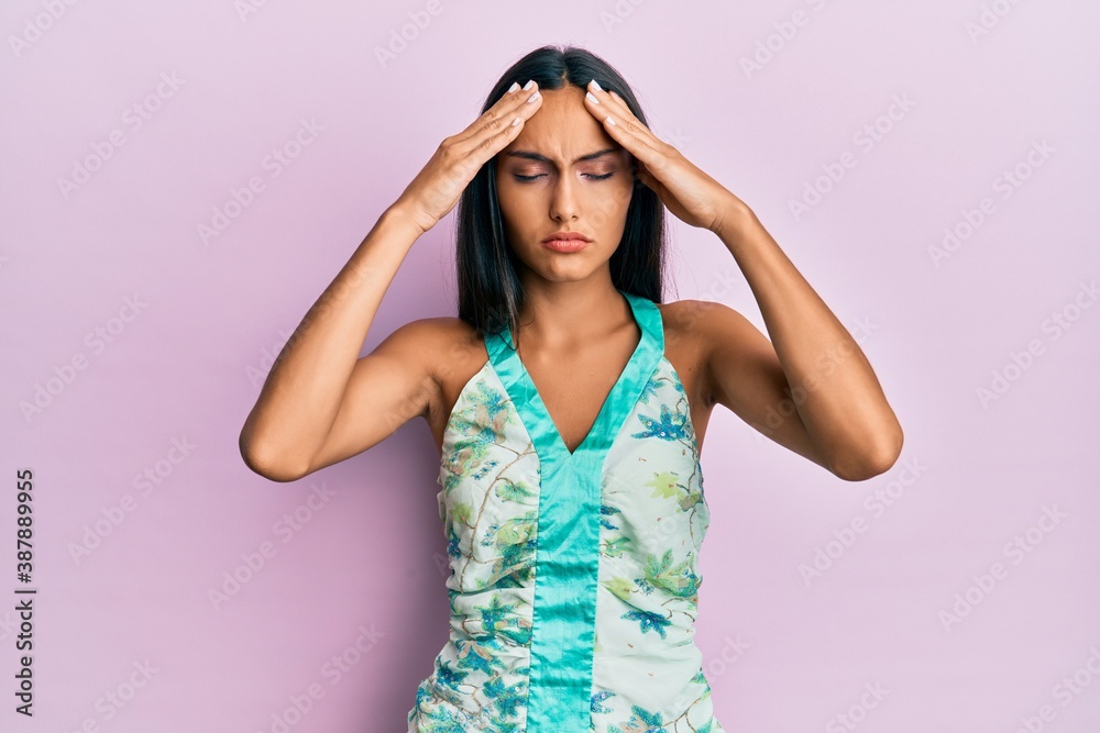 Young brunette woman wearing elegant summer shirt with hand on head, headache because stress. suffering migraine. Young brunette woman wearing elegant summer shirt with hand on head, headache because stress. suffering migraine.