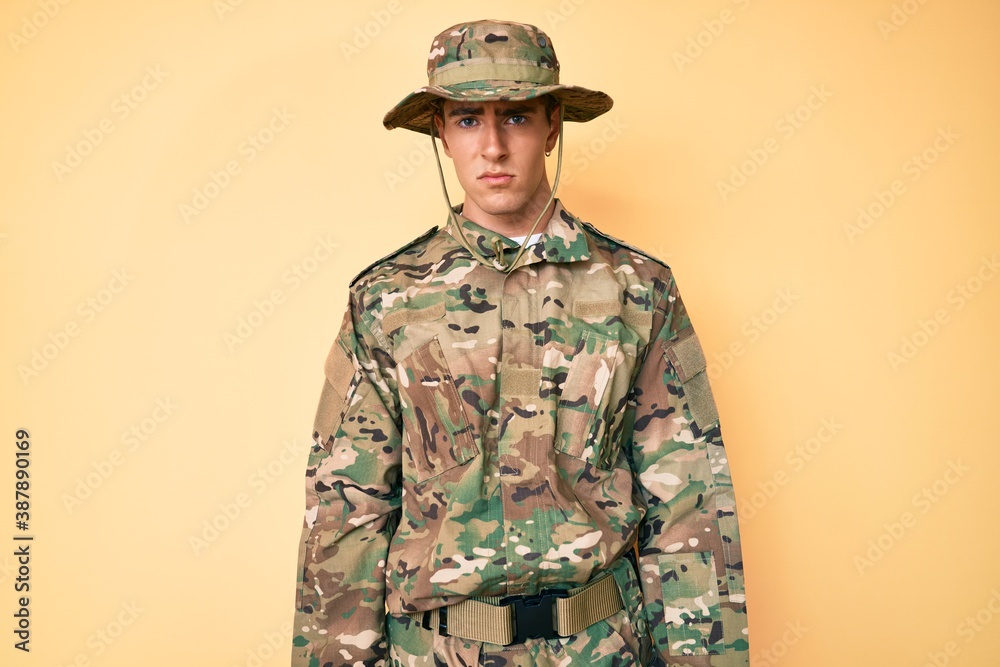 Young handsome man wearing camouflage army uniform skeptic and nervous, frowning upset because of problem. negative person. Young handsome man wearing camouflage army uniform skeptic and nervous, frowning upset because of problem. negative person.