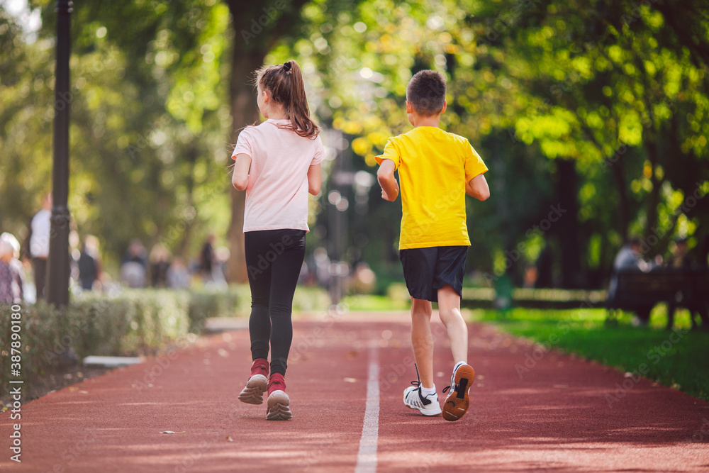 Kids run. Healthy sport. Child sport, heterosexual twins running on track, fitness. Joint training. Running training outdoor brother and sister pre-teen. Jogging with friend. Children athletes Kids run. Healthy sport. Child sport, heterosexual twins running on track, fitness. Joint training. Running training outdoor brother and sister pre-teen. Jogging with friend. Children athletes