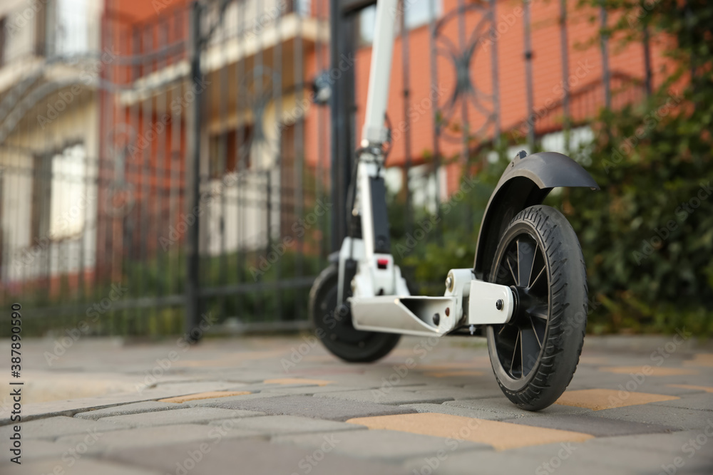 Modern electric kick scooter on city street, closeup