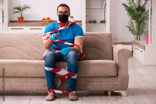 Young man watching tv at home in pandemic concept photo