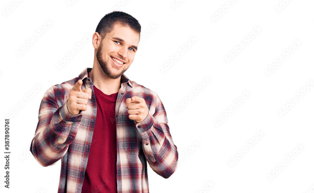 Naklejka premium Young handsome man wearing casual shirt pointing fingers to camera with happy and funny face. good energy and vibes.