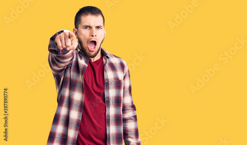 Young handsome man wearing casual shirt pointing displeased and frustrated to the camera  angry and furious with you