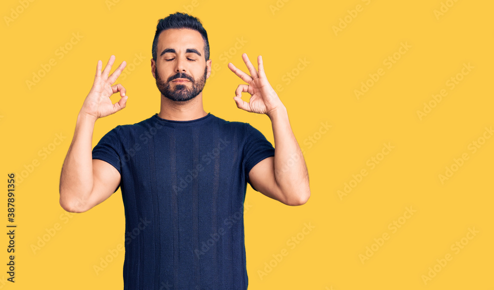 Young hispanic man wearing casual clothes relax and smiling with eyes closed doing meditation gesture with fingers. yoga concept. Young hispanic man wearing casual clothes relax and smiling with eyes closed doing meditation gesture with fingers. yoga concept.