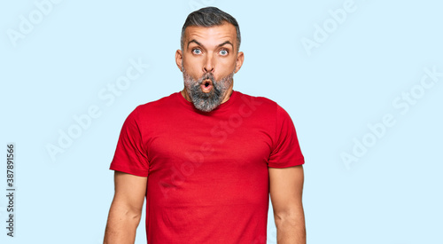 Middle age handsome man wearing casual clothes afraid and shocked with surprise expression, fear and excited face.